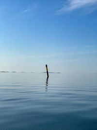 Man in sea against sky