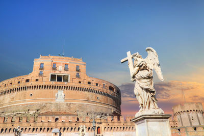 Low angle view of statue of historic building against sky