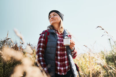 Woman taking break and relaxing with cup of coffee during trip. spending vacations close to nature