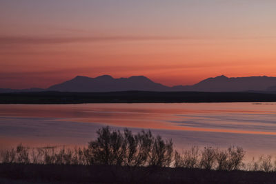 Scenic view of lake against romantic sky at sunset