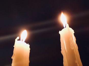 Close-up of lit candle in darkroom