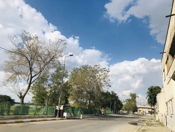 Street amidst trees against sky