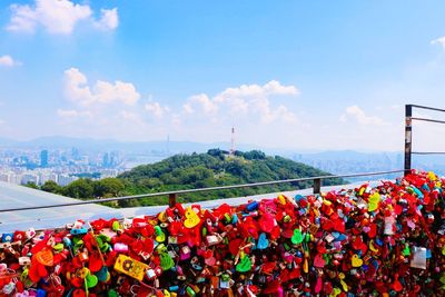 Low angle view of padlocks hanging on railing against sky