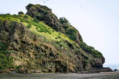 Rock formation on sea against clear sky