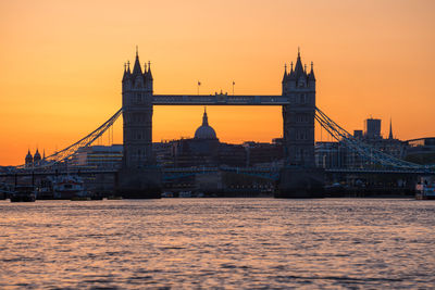 Bridge over river against clear sky during sunset