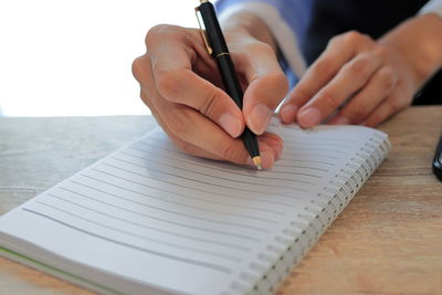 Close-up of hand holding book on table