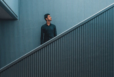 Full length of a smiling man standing on staircase