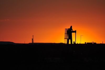 Silhouette water tower against sky during sunset