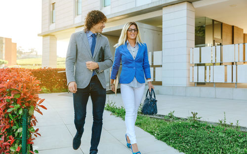 Full length of woman walking against building