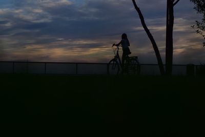 Silhouette of bicycle on beach at sunset