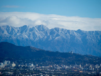 Aerial view of townscape and mountains against sky