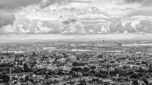 Aerial view of cityscape against cloudy sky