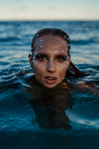 Portrait of young woman swimming in sea