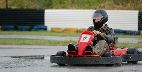Man driving racecar on wet motor racing track