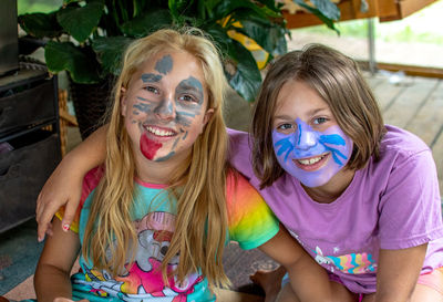 Sisters with happy smiles pose with newly painted faces