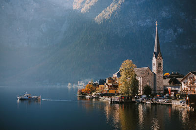 Panoramic view of lake by buildings against mountains