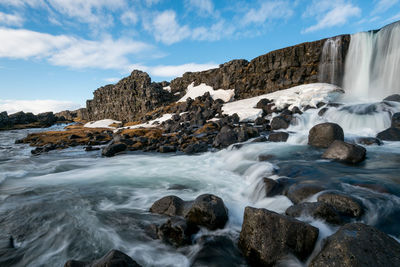 Scenic view of rocks in sea against sky