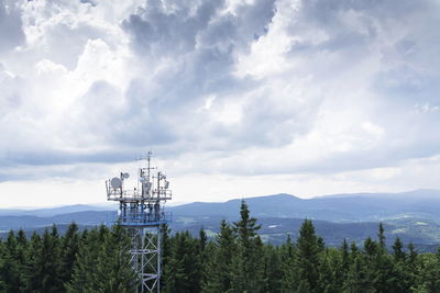 Communications tower against cloudy sky