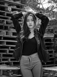 Portrait of young woman standing crate stack