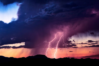 Low angle view of lightning against sky during sunset