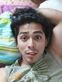 Portrait of smiling boy lying on bed at home