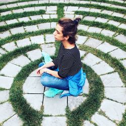 High angle view of young woman sitting on grass