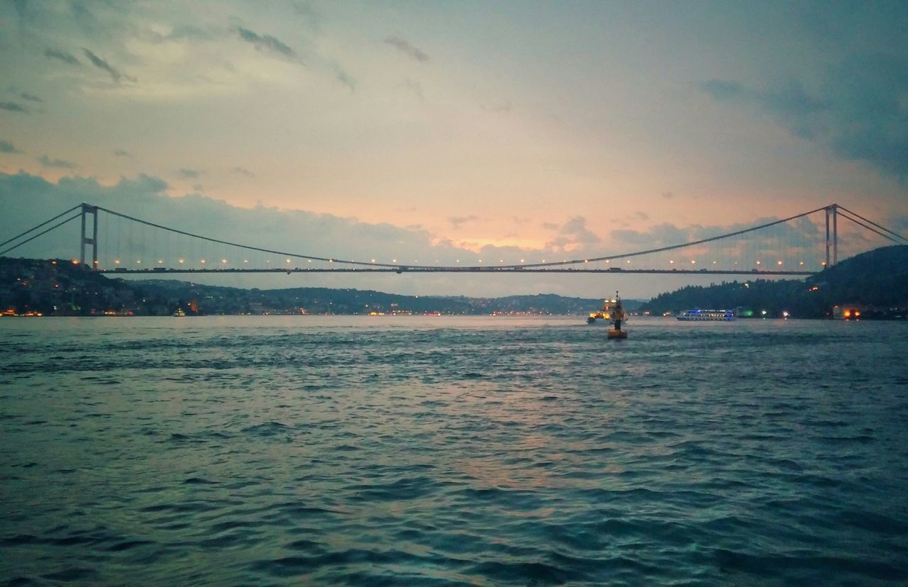 connection, bridge - man made structure, water, built structure, architecture, waterfront, suspension bridge, engineering, sky, river, transportation, bridge, sea, sunset, travel destinations, city, cloud - sky, rippled, travel, dusk