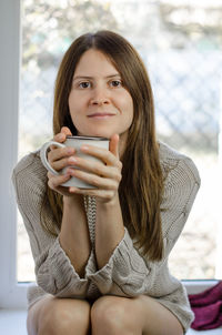 Portrait of young woman drinking coffee