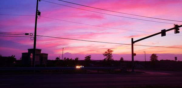 Silhouette electricity pylon against sky during sunset