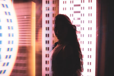 Rear view of woman standing against buildings