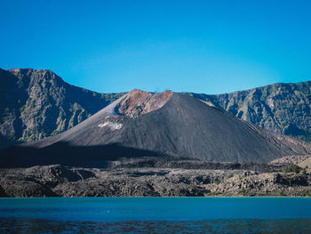Scenic view of volcanic mountain against clear blue sky