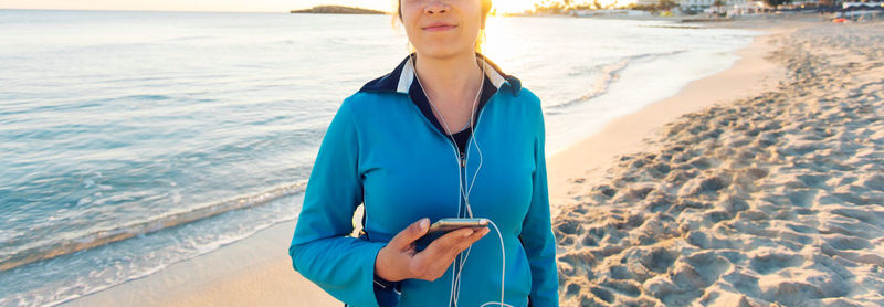 Midsection of woman standing on beach