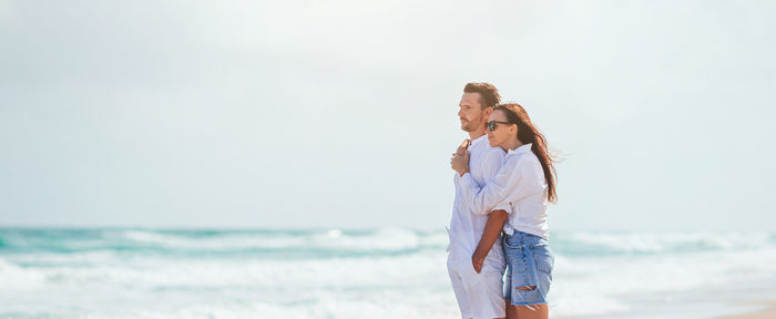 Rear view of woman standing at beach