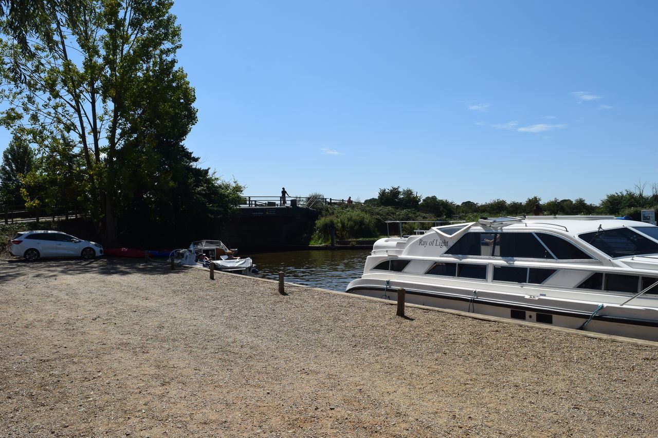 BOAT MOORED ON SHORE AGAINST SKY