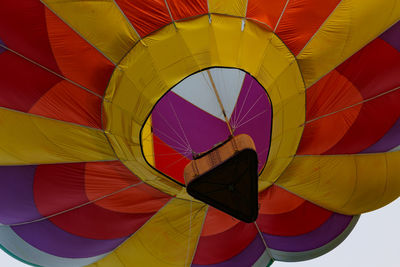 Multi colored hot air balloon flying against sky