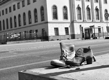 People sitting on street against building in city