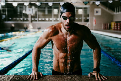 Full length of shirtless man swimming in pool