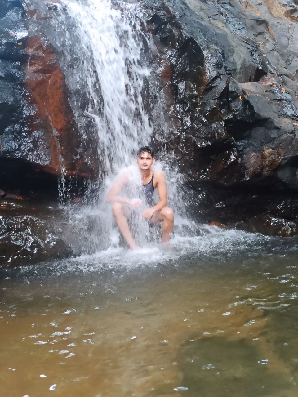 MAN SPLASHING WATER IN SEA