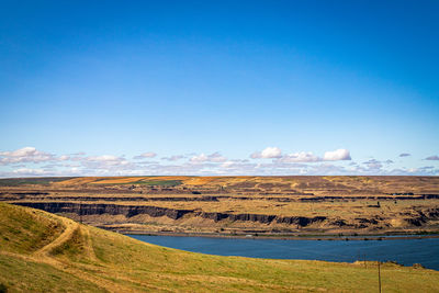 Scenic view of landscape against blue sky