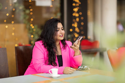 A beautiful indian woman checks her mail or writes a message on her phone, communicates with client