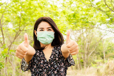 Portrait of young woman against plants