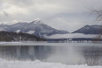 Scenic view of lake and snowcapped mountains against sky