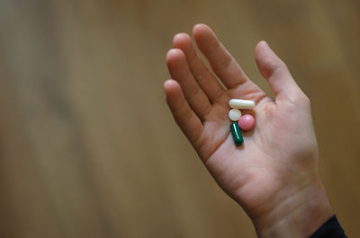 Cropped hand of woman holding pills