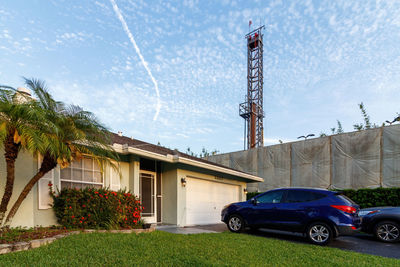 Cars on street by building against sky