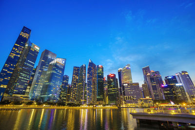 Low angle view of city lit up at waterfront