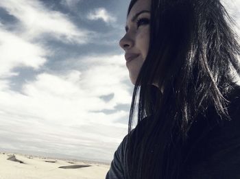 Portrait of woman looking away against sky