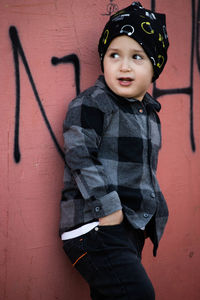 Portrait of boy standing against wall