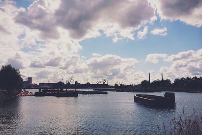Scenic view of river against cloudy sky