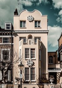 Low angle view of building against cloudy sky