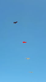 Low angle view of airshow against clear blue sky